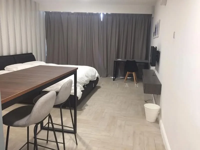 Room features: queen-size bed with white bedding, black upholstered bed frame, grey curtains, wooden dining table, 3 high-back bar stools, wall-mounted TV, light wood flooring, white walls, side table, waste bin; style: modern.