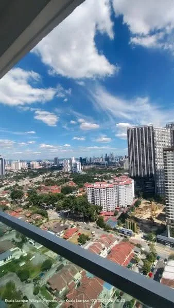 Exterior type: high-rise condominium; features: city skyline view, surrounded by greenery, adjacent to residential area, multiple high-rise buildings in view, clear blue sky, urban landscape, visible rooftops of low-rise buildings; style: modern.