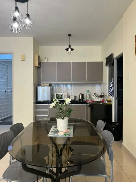 Kitchen features: grey cabinetry, stainless-steel fridge, built-in oven, electric kettle, toaster, dishwasher, black countertop, pendant lighting, dining table with glass top, grey upholstered dining chairs, white walls, tile flooring; style: modern.