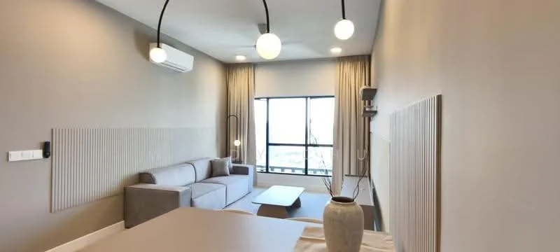 Living features: grey fabric sofa, coffee table, floor-to-ceiling window, sheer curtains, wall-mounted split AC, recessed downlights, 3-bulb pendant light, textured wall paneling, decorative vase; style: modern; view: city.