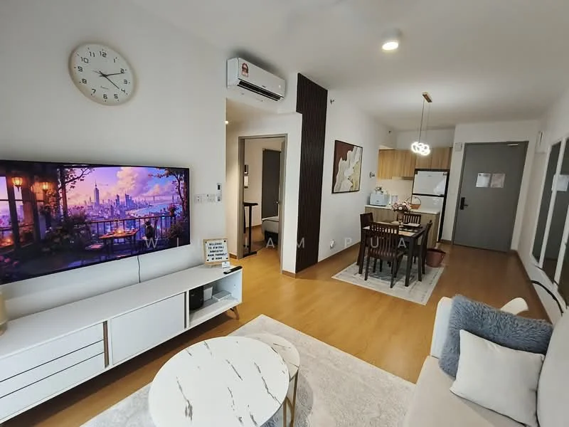 Living features: light wood flooring, white painted walls, wall-mounted TV, TV console with storage, 3-seater fabric sofa in beige, round coffee table with marble top, decorative wall art, clock on the wall, air conditioning unit, area rug with geometric pattern, floor lamp, dining area visible in background; style: modern. Kitchen features: kitchen cabinets in light wood, white countertop, stainless-steel fridge, built-in oven, freestanding range oven, microwave, open layout to living area; style: modern.