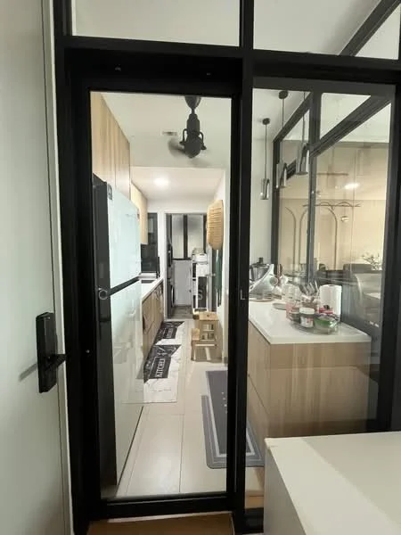 Kitchen features: glass sliding door, black frame, wood cabinetry, white countertop, stainless-steel fridge, built-in oven, microwave, kitchen island, pendant lighting, tile flooring, open shelving, decorative items on countertop, area rug; style: modern.