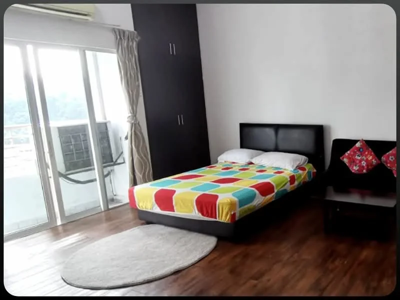 Bedroom features: queen-size bed with colorful bedding, two bedside tables, decorative cushions on bedside tables, wooden flooring, floor-to-ceiling windows, sliding glass door leading to balcony, curtains, air conditioning unit visible, round area rug; style: modern; view: city.