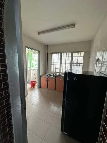 Kitchen features: black fridge, tile flooring, white tiled walls, kitchen cabinets in orange, multiple windows, sink area, light fixture on ceiling, cleaning supplies visible.