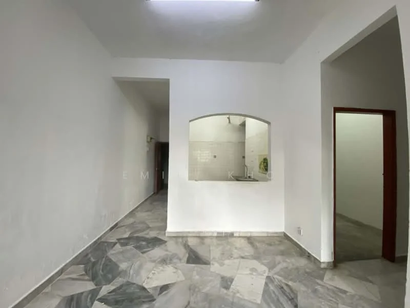 Room features: white painted walls, marble flooring, arched opening to kitchen, fluorescent ceiling light, doorway leading to another room, doorway leading to kitchen area.