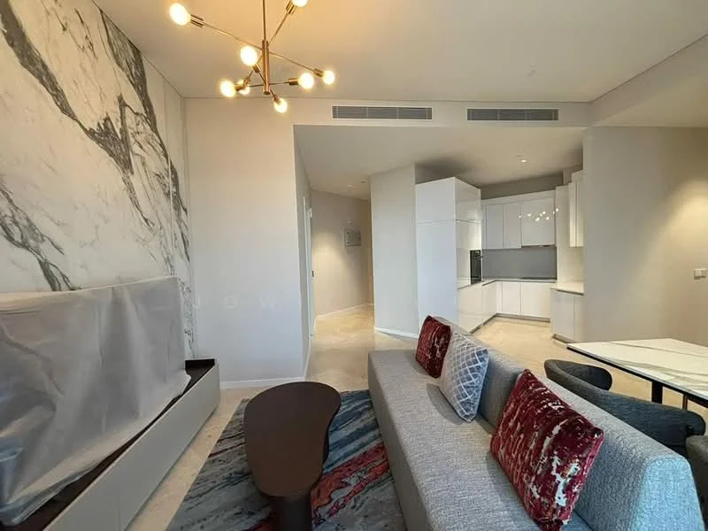 Living features: grey fabric sofa, red accent pillows, coffee table with wooden legs, marble feature wall, pendant light fixture, area rug with geometric pattern, wall-mounted TV console, open layout to kitchen, large windows for natural light, neutral wall color, recessed lighting, dining area visible in background; style: modern.