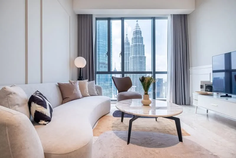 Living features: curved beige fabric sofa, round coffee table with marble top, floor-to-ceiling windows, city skyline view, light grey curtains, decorative vase with flowers, wall-mounted TV, light fixture with globe shade, accent chair in brown fabric, light-colored area rug, white media console; style: modern; view: city.