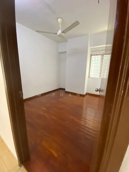 Room features: wooden flooring, white painted walls, ceiling fan, window with grid pattern, door frame, corner wall, plumbing fixture visible.