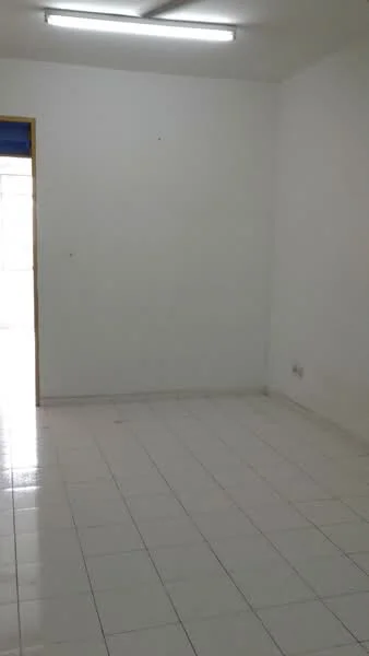 Room features: white painted walls, white tiled flooring, fluorescent ceiling lights, doorway leading to another space.