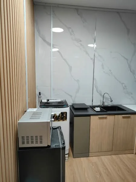 Kitchen features: marble wall cladding, wooden cabinetry, black countertop, single-bowl stainless-steel sink, chrome pull-down faucet, built-in washing machine, microwave, refrigerator, wooden paneling, vinyl plank flooring, recessed downlights; style: modern.