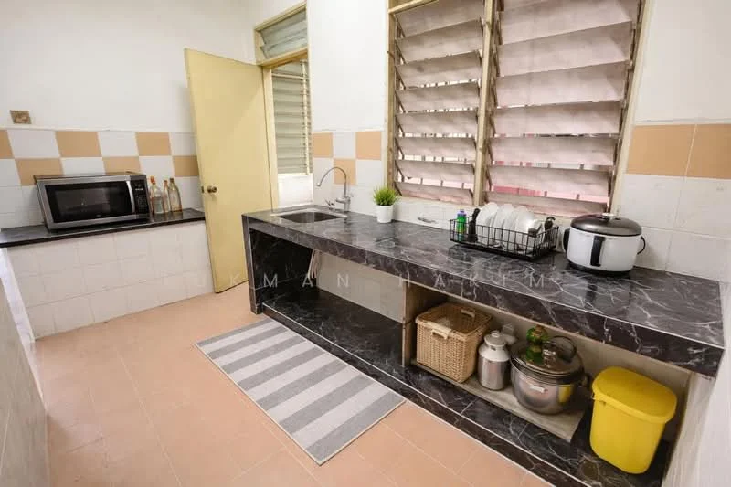 Kitchen features: black marble countertop, white tiled backsplash, single-bowl stainless-steel sink, chrome pull-down faucet, microwave, kitchen cabinet with open shelving, basket for storage, yellow storage container, grey area rug, window with slatted shutters, cream painted walls, tile flooring; style: modern.