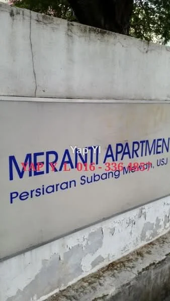 Exterior features: signage with 'MERANTI APARTMENT', concrete wall, text in blue and red, surrounding greenery.