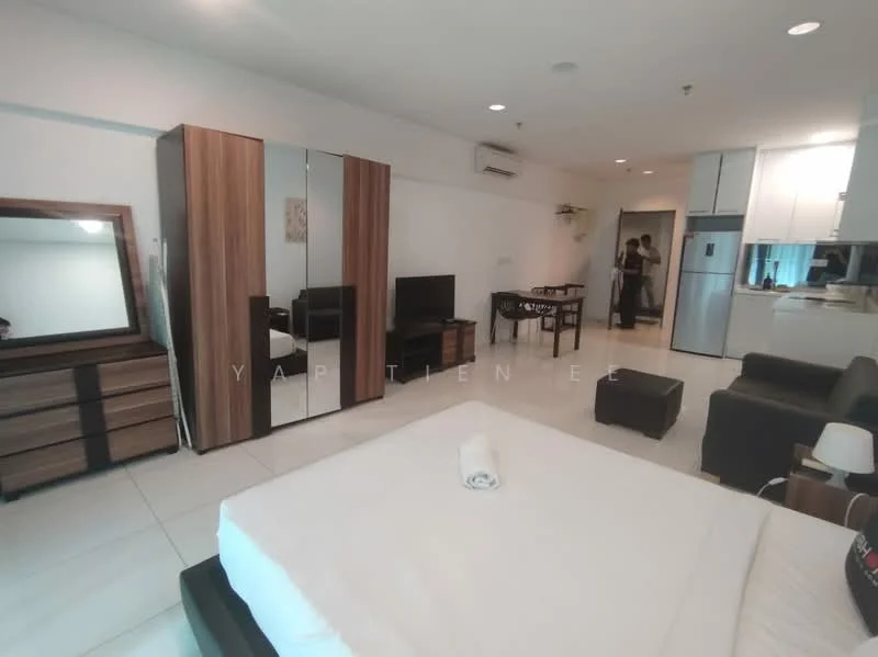 Room features: white painted walls, glossy tile flooring, queen-size bed with white bedding, wooden wardrobe with mirrored doors, wooden dresser with drawers, black leather sofa, TV console with flat-screen TV, refrigerator, air conditioning unit, ceiling light fixture, small bedside lamp, kitchenette area with countertop; style: modern.
