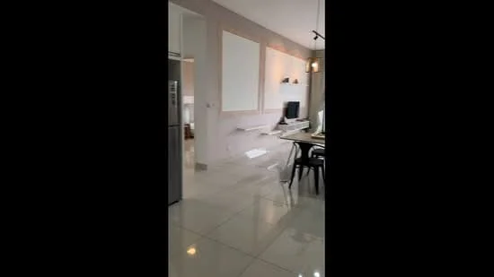 Room features: glossy tile flooring, light grey painted walls, recessed downlights, wall-mounted TV, white floating shelves, modern dining table, black dining chairs, stainless-steel fridge, open layout, large windows, minimalist decor; style: modern.