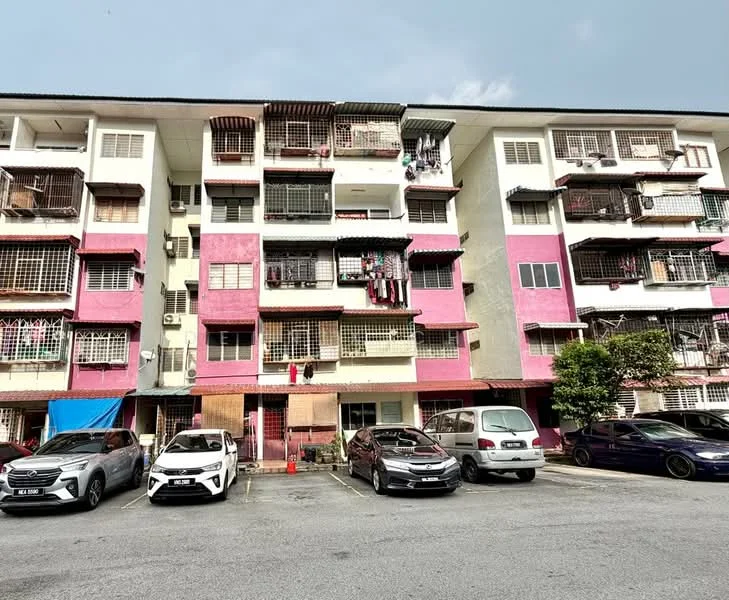 Exterior type: low-rise apartment block; features: pink and white painted facade, multiple balconies with metal grilles, visible air conditioning units, ground-level parking area, 4 parked cars, manicured landscaping in front, laundry hanging on balconies, windows with grilles; style: modern.