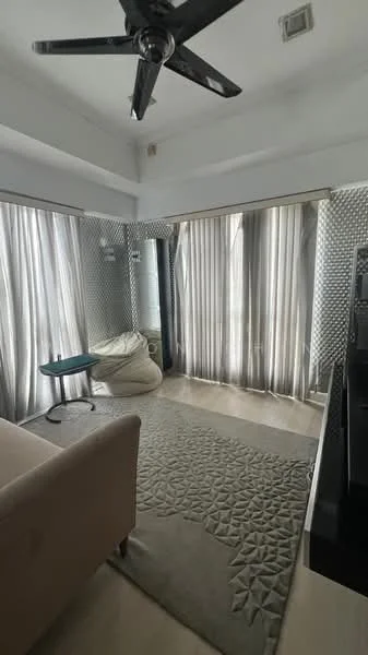 Living features: beige fabric sofa, area rug with geometric pattern, 5-blade ceiling fan with light, floor-to-ceiling windows, sheer curtains, light grey wall, cream tiled flooring, bean bag chair, small round side table; style: modern.