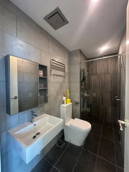 Bathroom features: grey tiled walls, dark grey floor tiles, walk-in shower with glass enclosure, chrome shower head, wall-mounted shower controls, single-sink vanity with wall-mounted mirror, white ceramic sink, toilet with concealed cistern, towel rack, cleaning supplies visible, recessed ceiling lights, exhaust fan; style: modern.