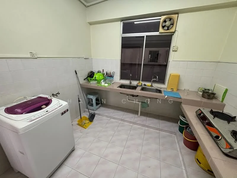 Laundry features: front-load washing machine in white, double-bowl stainless-steel sink, chrome pull-down faucet, countertop in beige, white tiled walls, light-colored tiled flooring, window with view to outside, ceiling fan, stove with two burners, plastic storage containers in various colors.