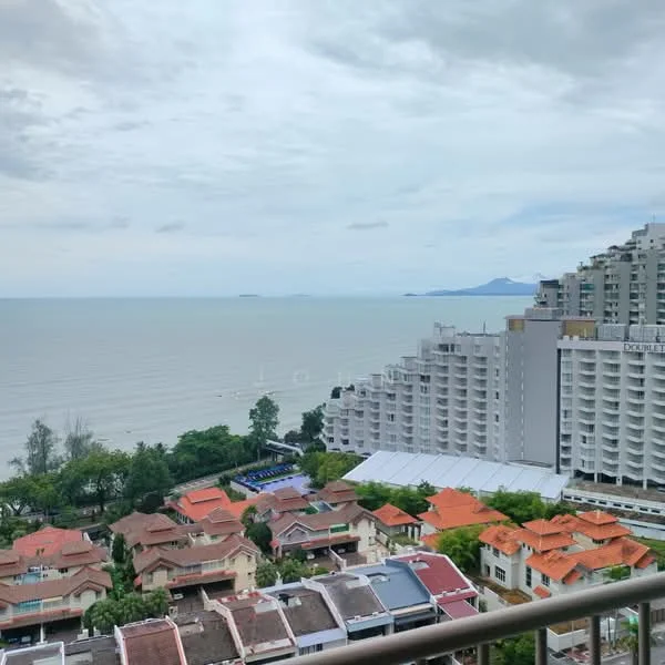 Exterior type: high-rise condominium; features: sea view, urban skyline, surrounded by greenery, multiple storey buildings, near waterfront, varied roof styles, balconies visible, landscaped gardens below; style: modern.