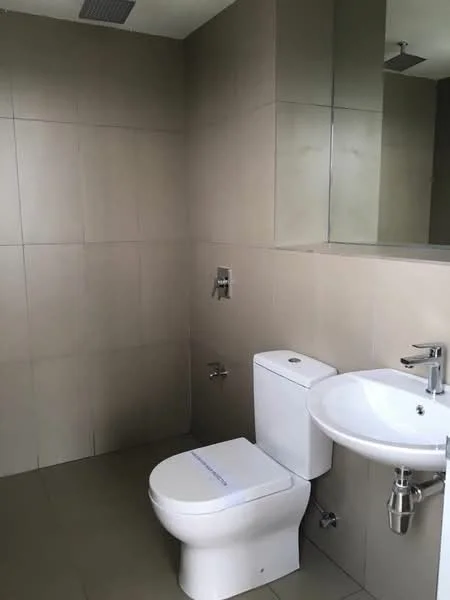 Bathroom features: white toilet, single-sink vanity with chrome faucet, mirror above sink, grey tiled walls, grey tiled flooring, wall-mounted faucet, shower head fixture, flush-mounted ceiling light; style: modern.