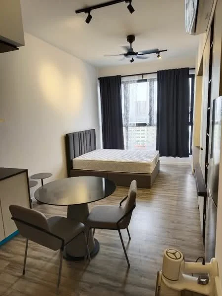 Room features: queen-size bed, upholstered headboard, floor-to-ceiling windows, blackout curtains, 3-blade ceiling fan, dining table, 2 upholstered dining chairs, laminate flooring, wall-mounted air conditioning unit, light-colored walls, kitchenette with cabinets, refrigerator; style: modern; view: city.