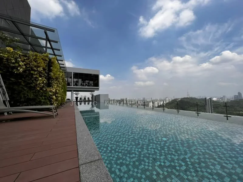 Exterior type: high-rise condominium; features: infinity pool, pool deck with loungers, glass railing, tiled pool surface with blue mosaic tiles, landscaped greenery, city skyline view, surrounded by hills, outdoor seating area; style: modern.