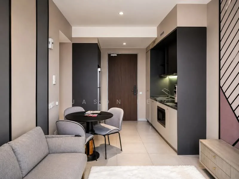 Living features: grey fabric sofa, round black dining table, two black dining chairs, light beige walls, dark grey accent wall, built-in kitchen cabinetry, black countertop, stainless-steel microwave, stainless-steel range hood, built-in oven, tile flooring, recessed downlights, door to hallway; style: modern.