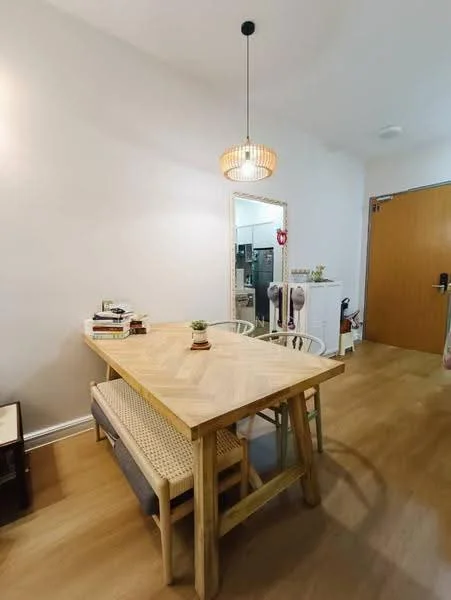 Dining features: wooden dining table, 4 dining chairs, pendant light fixture, decorative mirror, houseplant on table, light wood flooring, white painted walls, open kitchen view in background; style: modern.