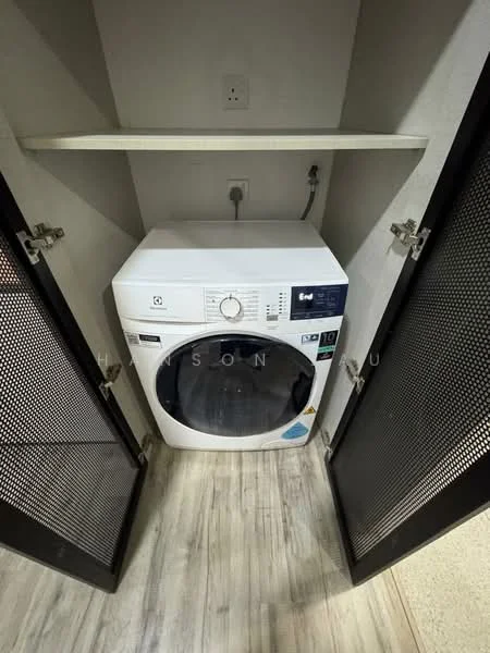 Laundry features: front-load washing machine, shelf above washing machine, grey cabinetry with mesh doors, light wood laminate flooring, wall-mounted electrical outlet, plumbing connection for washing machine; style: modern.