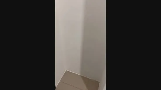 Room features: white painted walls, tile flooring, corner space.