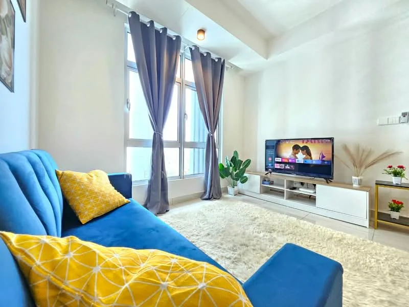 Living features: blue fabric sofa, yellow decorative throw pillow, white area rug, floor-to-ceiling windows, grey curtains, wall-mounted TV, white TV console, indoor plant, decorative shelf with plants, recessed ceiling lights; style: modern; view: city.