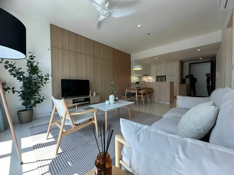 Living features: 3-seater fabric sofa in light grey, wooden coffee table, area rug with geometric pattern, floor-to-ceiling windows, wall-mounted TV, light wood feature wall, potted indoor plant, ceiling fan with light, decorative vase, dining area visible in background, open-plan layout; style: modern.
