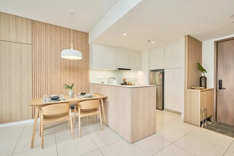 Kitchen features: white cabinetry, wood panel accent wall, island with countertop, stainless-steel fridge, built-in oven, ceramic tile flooring, recessed downlights, pendant light above dining table, dining table for four, wooden dining chairs, open shelving, plant decoration; style: modern.