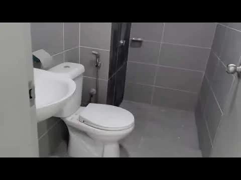 Bathroom features: white ceramic toilet, single-sink vanity with white countertop, chrome basin mixer faucet, grey wall tiles, grey floor tiles, glass shower enclosure, handheld shower, towel rail, toilet paper holder; style: modern.