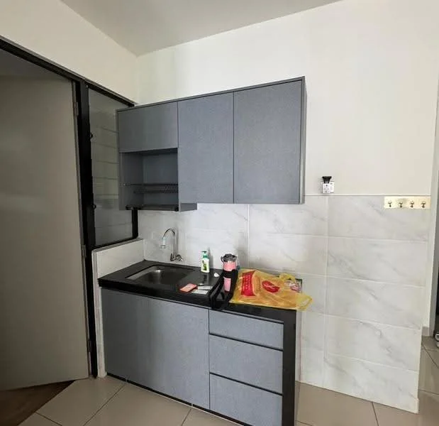 Kitchen features: grey cabinetry, black countertop, single-bowl stainless-steel sink, chrome pull-down faucet, white tiled backsplash, ceramic tile flooring, built-in shelves, kitchen appliances visible, wall-mounted light switch, door leading to another room; style: modern.