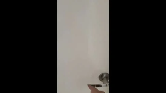 Room features: white painted walls, metal door handle, door with knob.