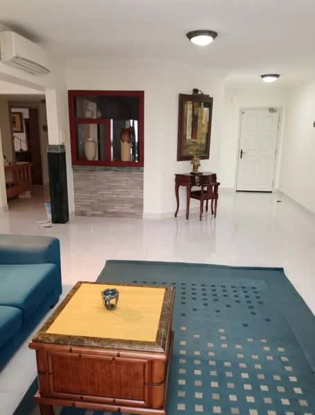Living features: blue fabric sofa, wooden coffee table with yellow top, area rug with geometric pattern, white walls, recessed ceiling lights, wall-mounted air conditioning unit, decorative wall art, wooden console table, door leading to hallway; style: contemporary. Room features: white walls, tile flooring, door leading to another room.