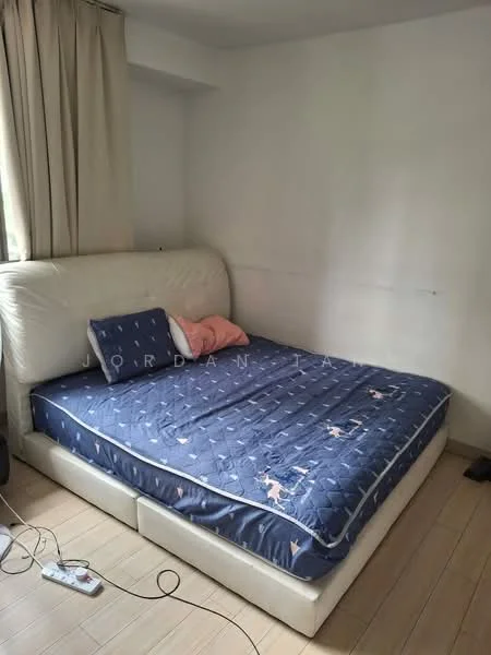 Bedroom features: queen-size bed with upholstered headboard, light blue bedding with pattern, two pillows, cream curtains, wooden flooring, white painted walls, nightstand with electrical cord visible.