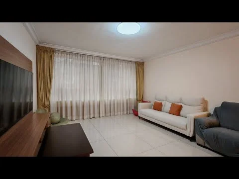 Living features: white painted walls, cream curtains, floor-to-ceiling windows, light-colored sofa with orange cushions, dark wooden TV console, light-colored tiled flooring, recessed ceiling light, decorative plants, beige armchair; style: modern.