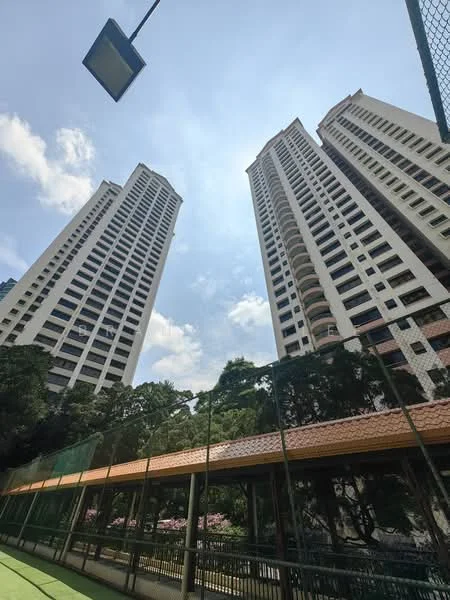 Exterior type: high-rise condominium; features: two tall residential towers, glass curtain wall, balconies on upper floors, surrounding greenery, tennis court in foreground, outdoor walkway, street lamp, clear blue sky; style: modern.