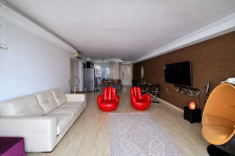 Living features: white leather sofa, two red accent chairs, wooden flooring, flat-screen TV mounted on wall, decorative wall paneling, area rug with intricate pattern, glass coffee table, recessed ceiling lights, open layout, large windows for natural light; style: modern.
