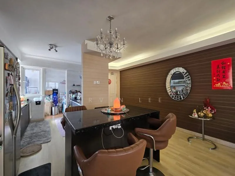 Dining features: black dining table, 4 brown leather dining chairs, chandelier, wood panel accent wall, round mirror, decorative wall art, laminate flooring, recessed lighting; style: modern. Kitchen features: stainless-steel refrigerator, built-in cabinets, countertop, kitchen appliances visible, open layout to dining area; style: modern.