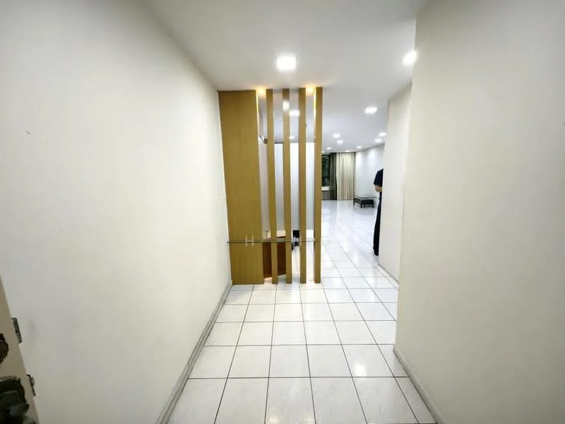 Hallway features: white painted walls, white tiled flooring, recessed ceiling lights, wooden feature wall with vertical slats, open layout leading to living area, doorway leading to other rooms; style: modern.