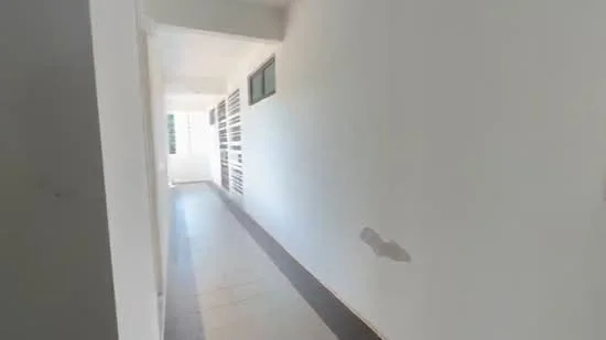 Room features: white painted walls, tile flooring, windows along hallway, natural light from windows, narrow hallway layout.