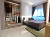 Bedroom features: queen-size bed with grey bedding, upholstered headboard, built-in wardrobe with sliding doors, open shelving in wardrobe, decorative throw pillows, area rug with geometric pattern, floor-to-ceiling window with sheer curtains, recessed downlights, cream painted walls, glossy tile flooring; style: modern; view: city.