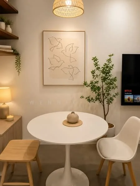 Dining features: round white dining table, white plastic dining chairs, wooden stool, pendant light fixture, framed abstract artwork on wall, decorative plant, wall-mounted TV, shelf with books and decor, soft ambient lighting from lamp, concrete flooring; style: modern.