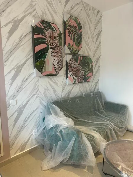 Living features: green fabric sofa, decorative wall art with animal prints, marble-patterned wallpaper, light-colored flooring, coffee table, plastic covering on furniture; style: modern.