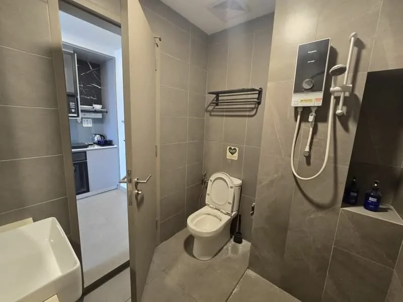 Bathroom features: grey tiled walls, grey tiled flooring, one-piece toilet, shower with handheld showerhead, wall-mounted shower control, sink with modern design, towel rack, soap dispenser, mirror, built-in shelf; style: modern.
