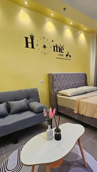 Bedroom features: yellow painted walls, grey upholstered bed with headboard, queen-size bed, grey fabric sofa, coffee table, decorative wall clock, wall-mounted lighting, area rug with geometric pattern, potted plants, bed linens in neutral tones; style: modern.