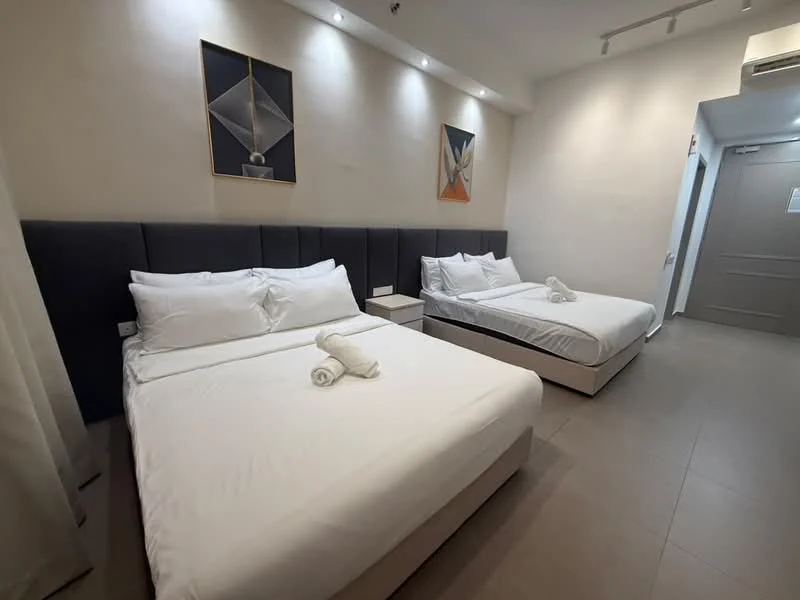 Bedroom features: two queen-size beds, upholstered headboards in grey, white bedding, white towels, nightstand with drawer, framed artwork on walls, recessed lighting, light-colored walls, tile flooring, air conditioning unit; style: modern.